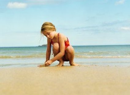 dziecko piszące na piasku