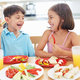 Dzieci jedzące świeże warzywa